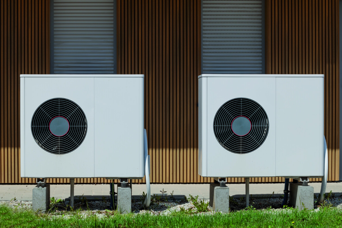 Air source heat pumps featured on modern house front. Renewable